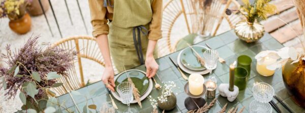 Woman creating a tablescape design in earth tones using natural elements