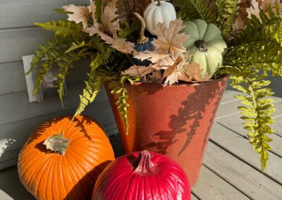 fall silks in urn with painted pumpkins